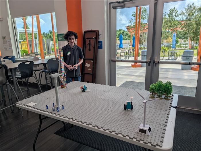 Students build and test small robots at a work table.